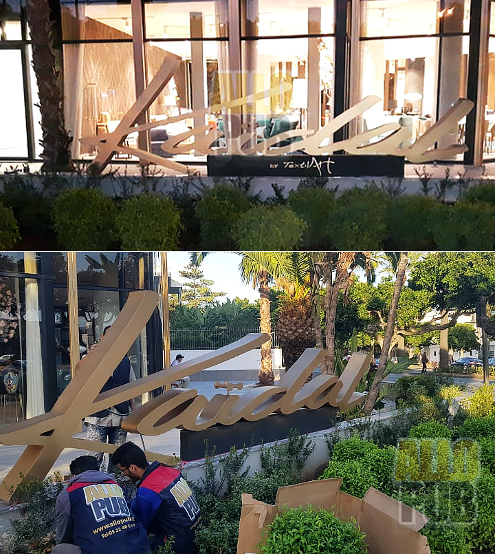 Grandes lettres en bois de l’enseigne Kaidal installées dans un jardin